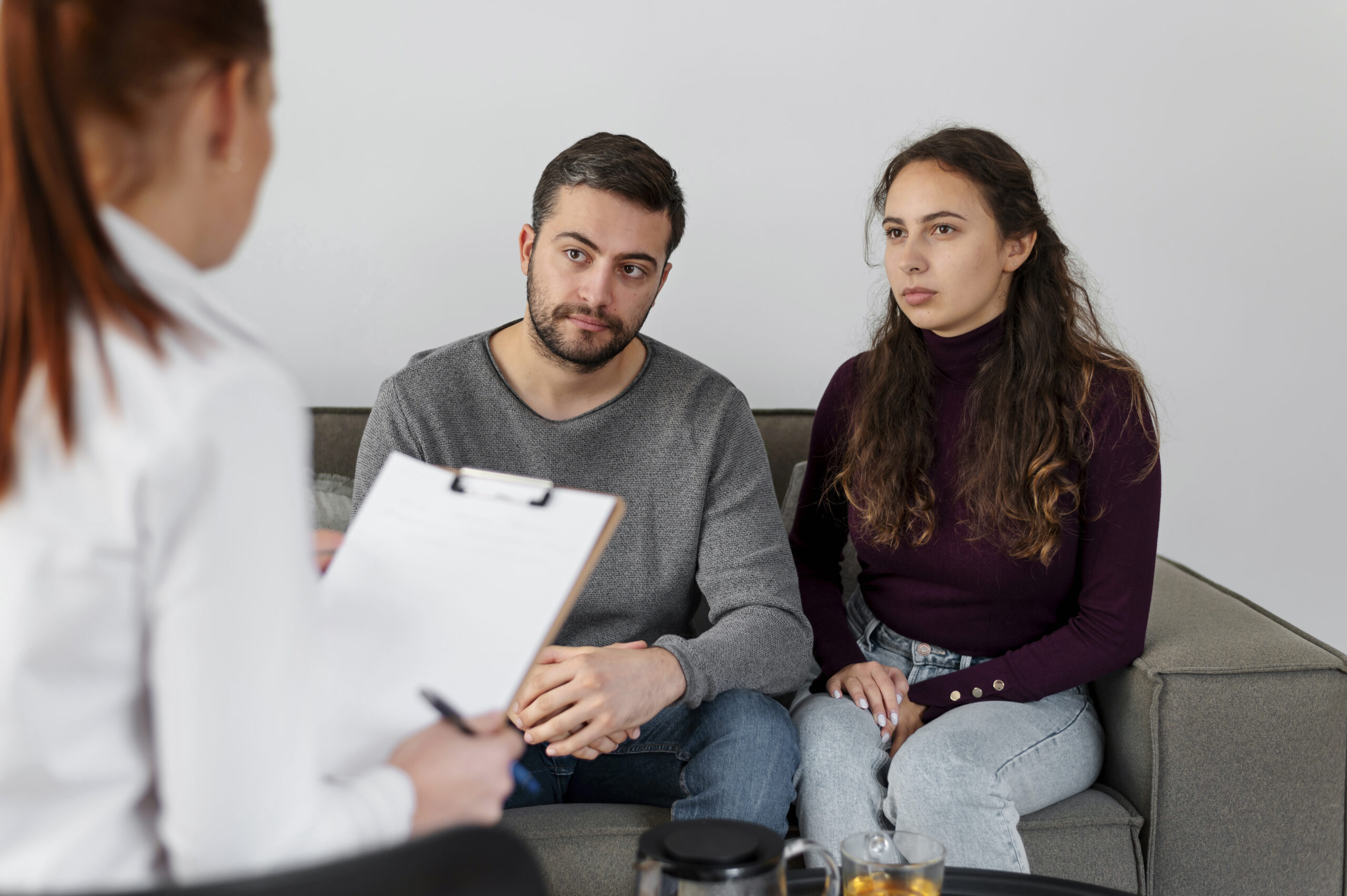 Couple discussing relationship concerns with therapist in counseling session.